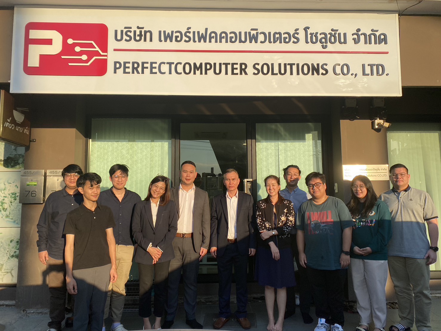 Perfect Computer Solutions 团队在公司办公室门前合影